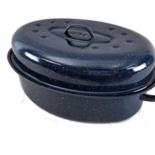 Large blue covered oval roasting pan with lid on countertop next to roasted turkey and vegetables