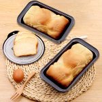 MANO set of two 9×5 inch nonstick carbon steel loaf pans with rolled rims and handles, ideal for baking bread and meatloaf.