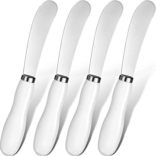 A set of four stainless steel butter spreader knives with white porcelain handles, perfect for kitchen use.