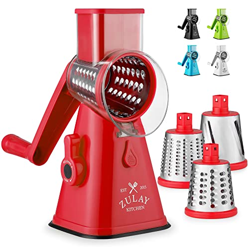 A pink rotary cheese grater with a crank handle and interchangeable stainless steel blades, ideal for effortless kitchen prep.